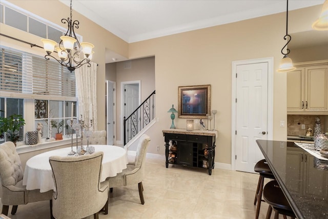 dining area with crown molding and a chandelier