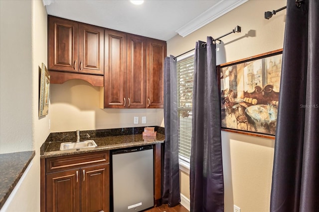 kitchen with ornamental molding, stainless steel dishwasher, dark stone counters, and sink