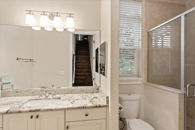 bathroom with toilet, walk in shower, and vanity