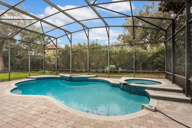 view of pool featuring an in ground hot tub, a patio area, and glass enclosure