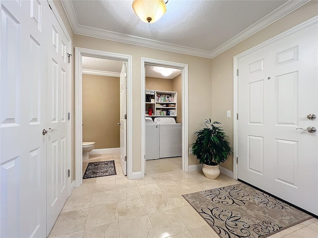 interior space featuring a textured ceiling, light tile patterned floors, crown molding, and washing machine and clothes dryer