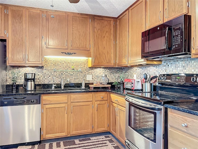 kitchen with backsplash, sink, stainless steel appliances, a textured ceiling, and dark stone counters