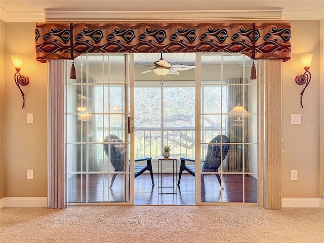 carpeted dining room featuring ceiling fan and crown molding