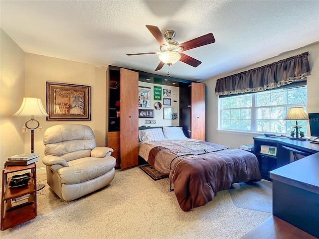 bedroom featuring ceiling fan, a textured ceiling, and carpet