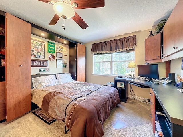 bedroom featuring ceiling fan, a textured ceiling, and light carpet