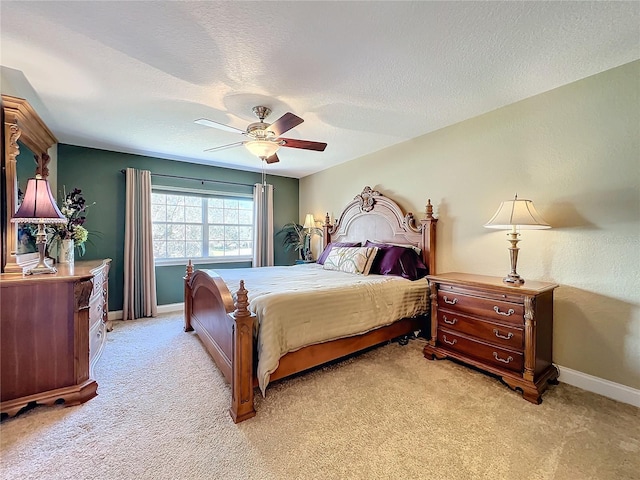 bedroom featuring a textured ceiling, ceiling fan, and light colored carpet