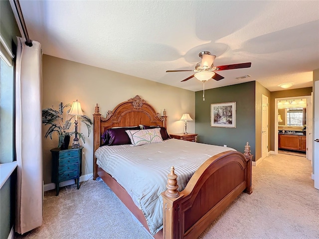 carpeted bedroom with ceiling fan and connected bathroom