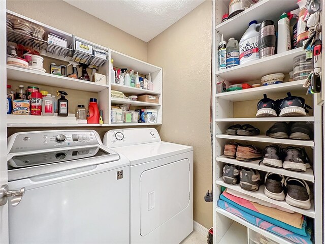 clothes washing area with a textured ceiling and washing machine and dryer