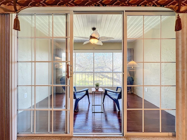 unfurnished sunroom featuring ceiling fan and french doors