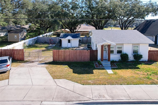 view of front facade featuring a front yard and a storage shed