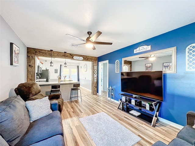 living room with ceiling fan, sink, and light wood-type flooring