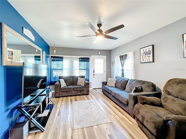 living room featuring hardwood / wood-style flooring, a textured ceiling, and ceiling fan