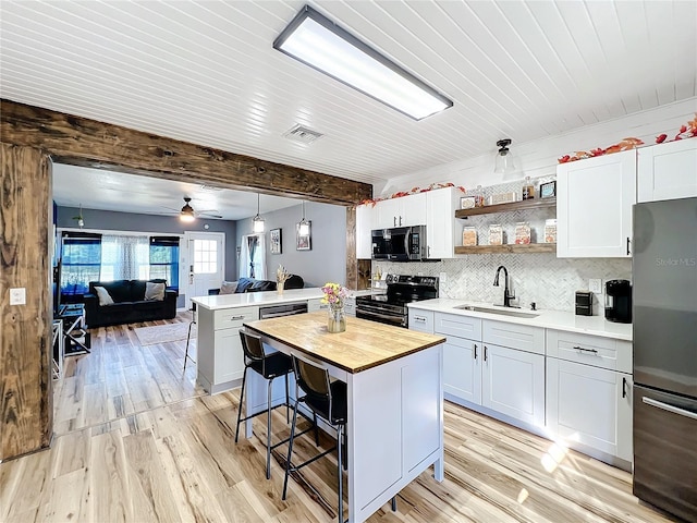 kitchen featuring decorative light fixtures, sink, a kitchen bar, a center island, and stainless steel appliances