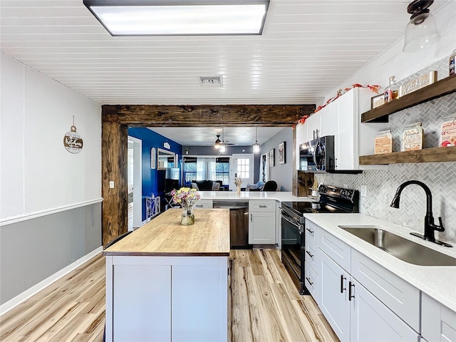 kitchen featuring black electric range oven, sink, dishwasher, white cabinetry, and a kitchen island