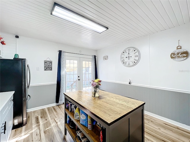 dining room with french doors and light hardwood / wood-style flooring