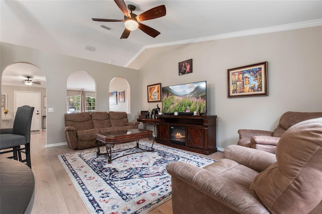 living room featuring ceiling fan, crown molding, lofted ceiling, and light wood-type flooring