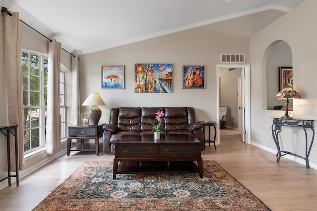 living room with ornamental molding, lofted ceiling, and light wood-type flooring