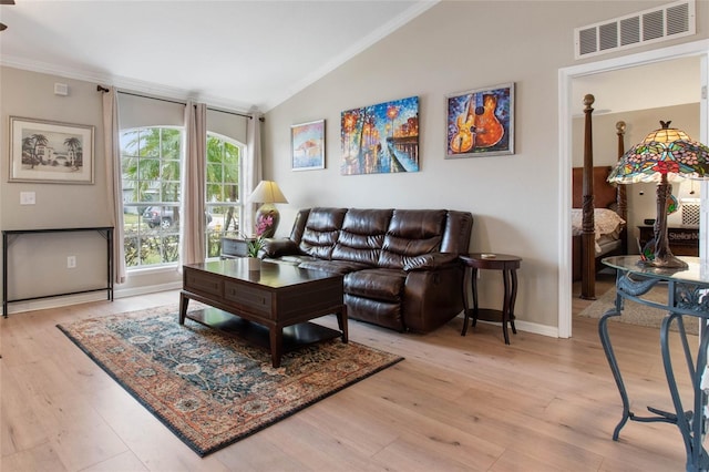 living room featuring vaulted ceiling, crown molding, and light hardwood / wood-style floors