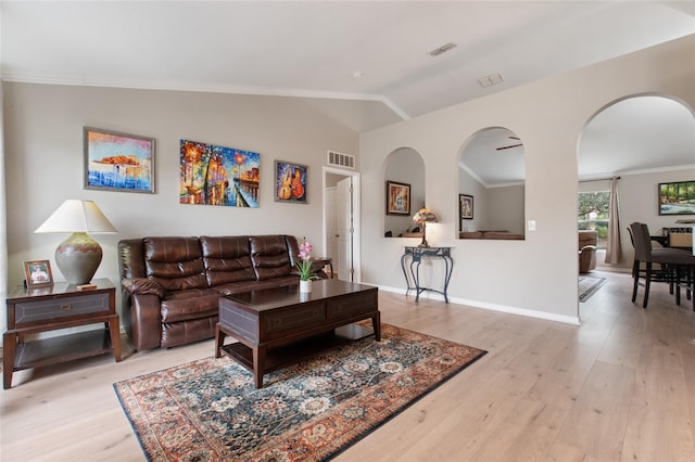 living room with crown molding, light hardwood / wood-style flooring, and lofted ceiling