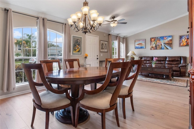 dining space featuring lofted ceiling, a wealth of natural light, crown molding, and light hardwood / wood-style flooring