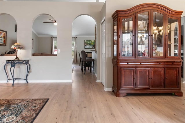 interior space featuring ceiling fan, ornamental molding, and light hardwood / wood-style flooring