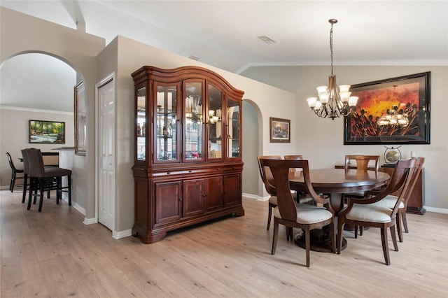 dining space with vaulted ceiling, a chandelier, light hardwood / wood-style floors, and ornamental molding