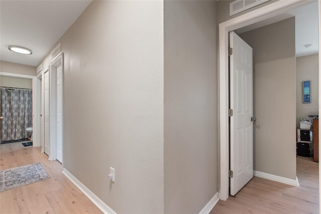 hallway with light hardwood / wood-style floors