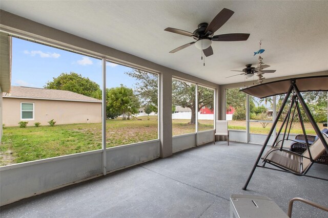 unfurnished sunroom featuring ceiling fan