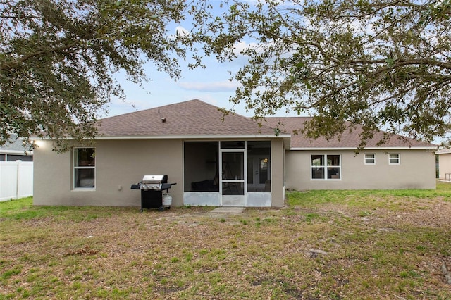 rear view of property with a sunroom and a yard