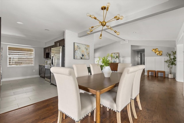 dining room featuring a chandelier, baseboards, and wood finished floors
