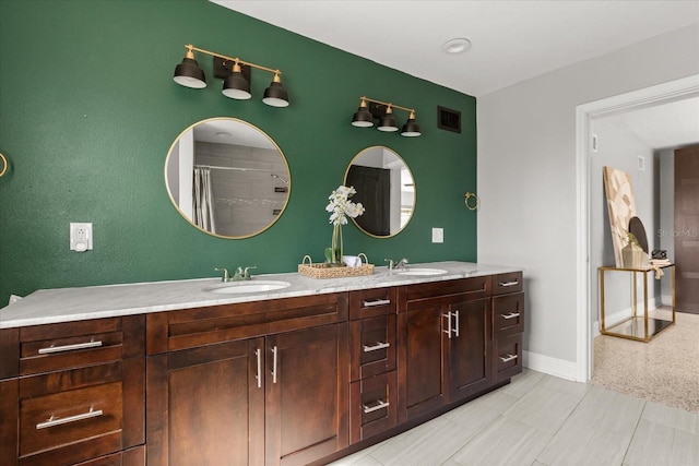 bathroom with double vanity and baseboards