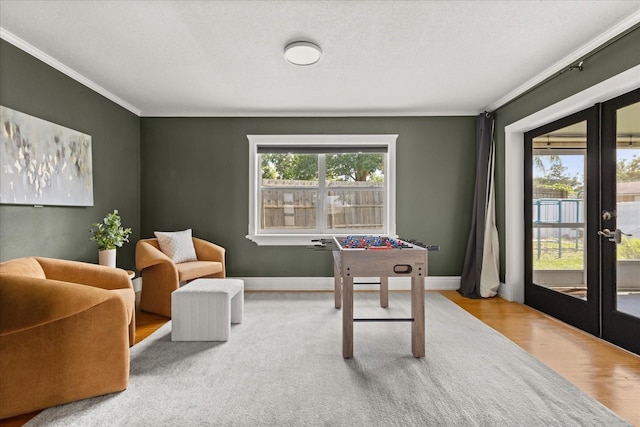 game room with french doors, crown molding, wood finished floors, and baseboards