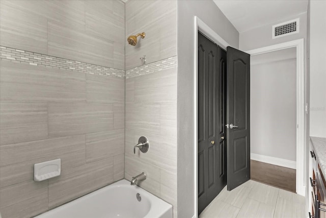 bathroom featuring tub / shower combination, baseboards, and tile patterned flooring