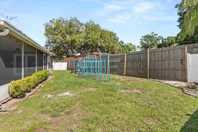 view of yard with a playground and a sunroom