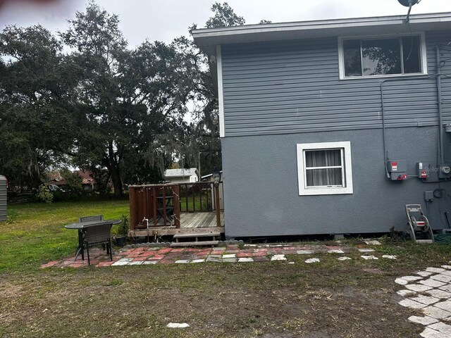 view of side of home featuring a deck and a yard