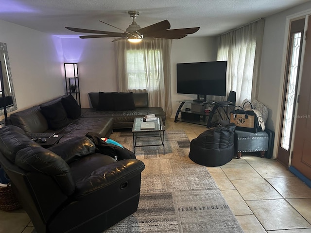 living room with ceiling fan, a textured ceiling, and a healthy amount of sunlight