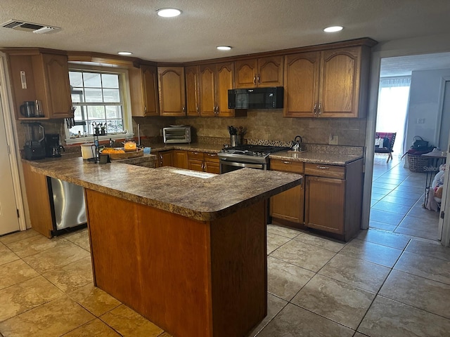 kitchen with a wealth of natural light, backsplash, stainless steel range with gas stovetop, and light tile patterned floors