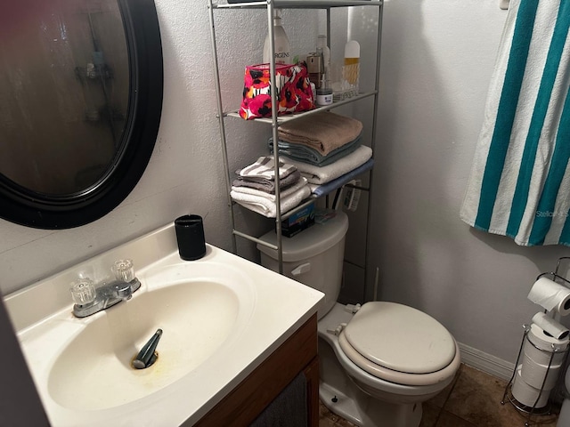 bathroom featuring tile patterned floors, vanity, and toilet