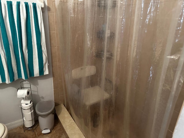 bathroom with tile patterned floors, toilet, and a shower with shower curtain