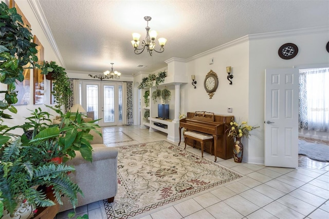 living room featuring a textured ceiling, french doors, ornamental molding, a notable chandelier, and light tile patterned floors