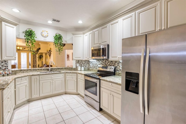 kitchen featuring light stone counters, sink, backsplash, and appliances with stainless steel finishes