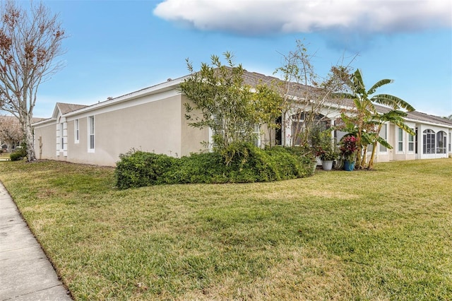 view of side of property with a lawn