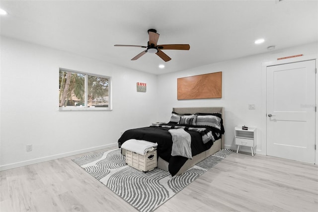 bedroom with ceiling fan, heating unit, and light wood-type flooring