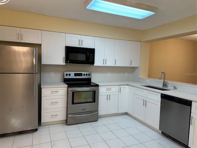 kitchen with light tile patterned floors, appliances with stainless steel finishes, white cabinets, and sink