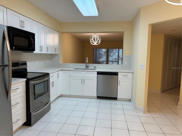 kitchen with light tile patterned floors, appliances with stainless steel finishes, pendant lighting, white cabinets, and sink