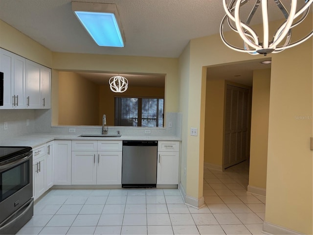 kitchen with appliances with stainless steel finishes, a chandelier, white cabinetry, and sink