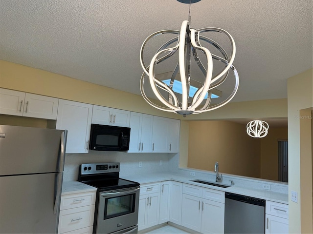 kitchen featuring a textured ceiling, appliances with stainless steel finishes, white cabinetry, and sink