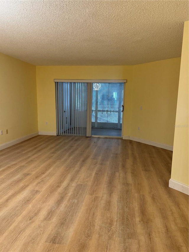 empty room featuring a textured ceiling and light wood-type flooring