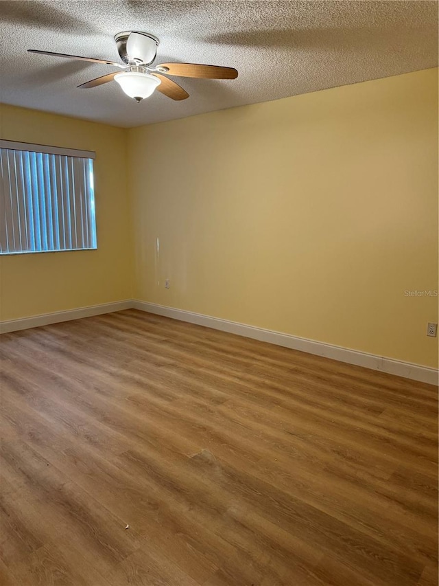 empty room with hardwood / wood-style flooring, a textured ceiling, and ceiling fan