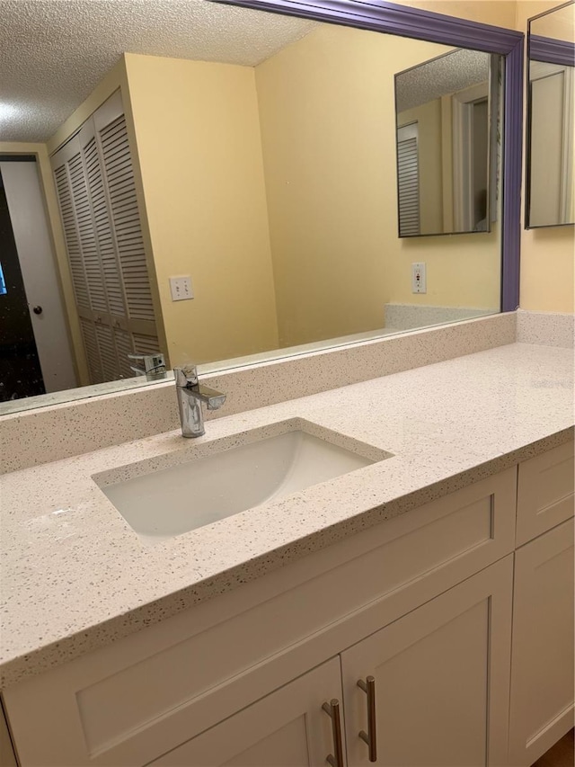 bathroom with a textured ceiling and vanity